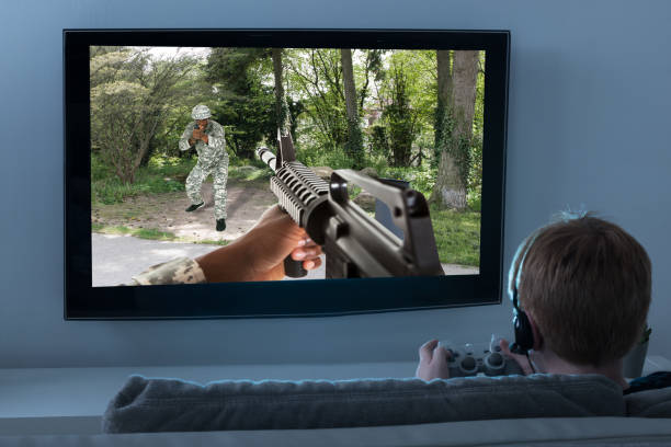 Boy Sitting On Sofa Playing Action Game On Television